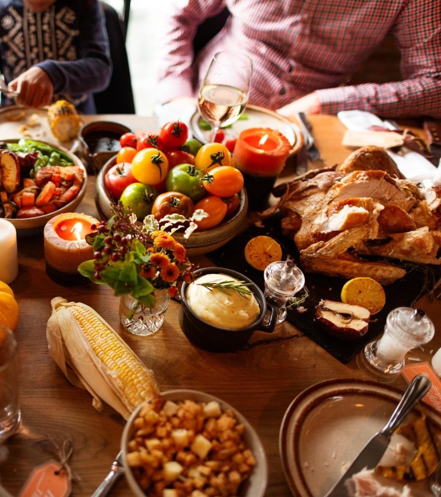 A Thanksgiving table with roast turkey, pumpkin pie, corn and seasonal sides